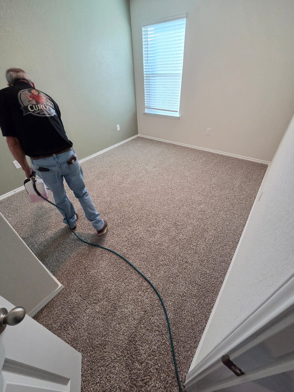 Curly's technician pre-treating a carpet in a San Antonio home